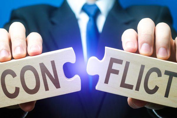 Man breaks puzzles with word Conflict. Resolution of disputes and conflicts in negotiations. Come to a general agreement. Stop confrontation. Mediator. Diplomacy and Geopolitics. Get along with others